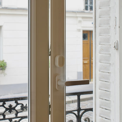 Close-up of a door handle on a window with a zensor device